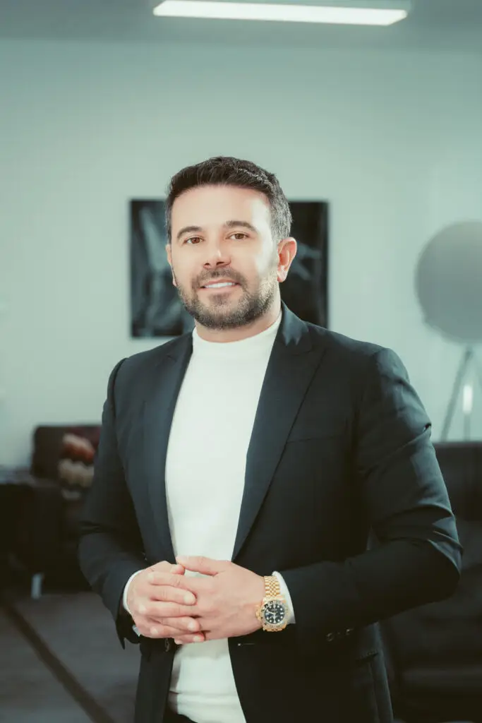 Dr. Mehmet Atila im dunklen Anzug mit hellem Rollkragenpullover